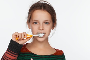 Portrait of an eight-year-old girl who brushes her teeth with a toothbrush