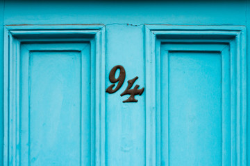 House number 94 on a blue or turquoise front door