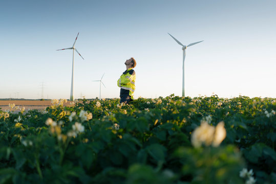 Engineer standing in a field at a wind farm