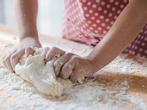 Kid hands preparing dough for pizza or bread, lifestyle concept, motion blur.