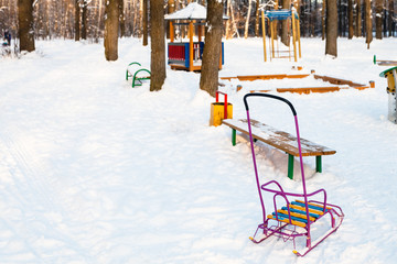 snow-covered playground in urban park in winter