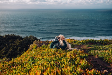 Fototapeta premium Golden Retriever and its owner are looking at the ocean. Travel with a dog.