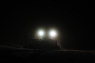 snowcat at night searchlight