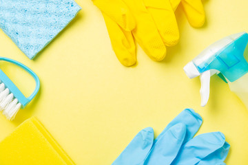 Cleaning concept - blue and yellow cleaning supplies, gloves, bottles, copy space