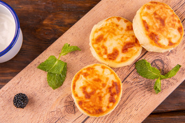Cheesecakes, are served with sour cream and leaflets of mint