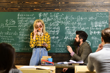 Student Studying Hard Exam. Student conference in loft interior coworking space using digital devices and wifi. Students preparing for exams in classroom interior behind table.