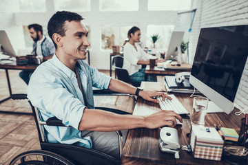 Man on Wheelchair Working on Computer in Office.