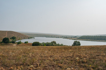 Freshwater reservoir in the Luhansk steppes in Ukraine. Summertime landscape panorama of region of Ukraine near to Russia