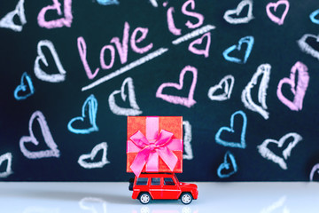 Concept Of Valentine's Day. Red typewriter and red gift box on dark