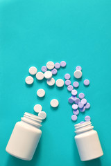 pills scattered on a blue background. pills spilled out of the bottle. copy space for text