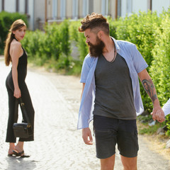 Feeling flirtatious. Bearded man and cute woman walk on street. Hipster look back at pretty woman....