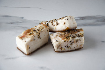 Several pieces of pickled traditional lard with spieces on the white table