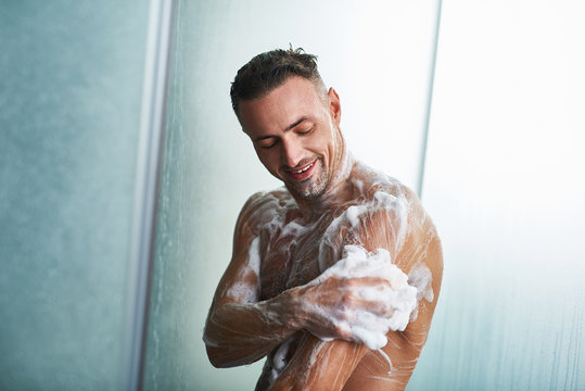 Handsome Young Man Washing Himself With Shower Gel