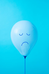 blue balloon with a sad face