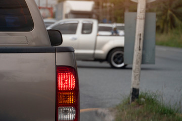 Brown car break on the road by traffic light control with cars cross the intersection at day.