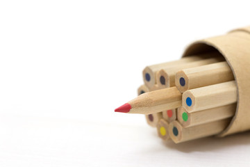 Red pencil standing out from crowd on white table. Leadership, uniqueness, independence, initiative, strategy, dissent, think different, business success concept.