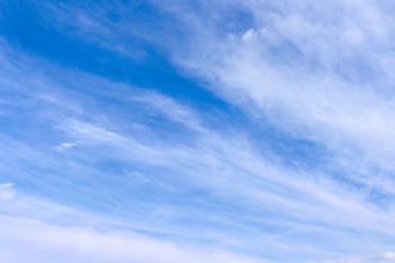 Clouds and light breeze on bright blue sky background