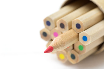 Red pencil standing out from crowd on white table. Leadership, uniqueness, independence, initiative, strategy, dissent, think different, business success concept.