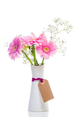 bunch of pink gerberas in vase isolated on white with empty tag för mothers day
