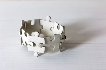 Group of white jigsaw puzzle on wooden table. Business teamwork and collaborate  concept.
