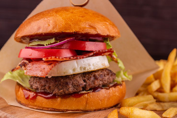 Hamburger with cutlet and bacon, grilled vegetables and tomato sauce