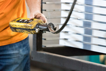 A male worker operating an industrial remote switch.