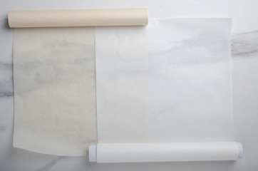Two types of paper for baking on marble table