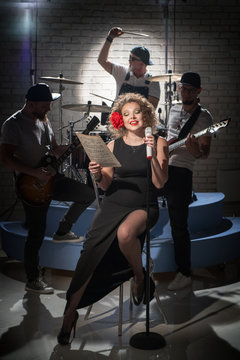 A woman with a rose in her hair sings the notes