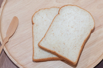 close up of sliced bread on wooden tray