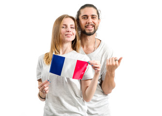 Fototapeta premium Happy couple in gray t-shirts with the flag of France isolated on white background. Learn French. Young people, man and woman.