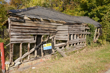 Old dilapidated wooden shed with Danger Keep Out sign to warn people that it might collapse
