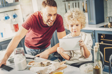 Smart friendly boy and man rereading receipt