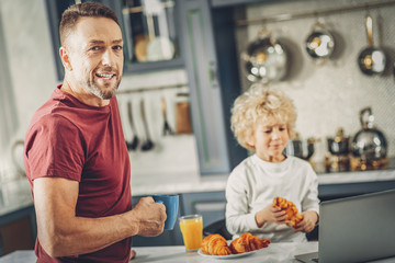 Handsome active man and boy tasting breakfast