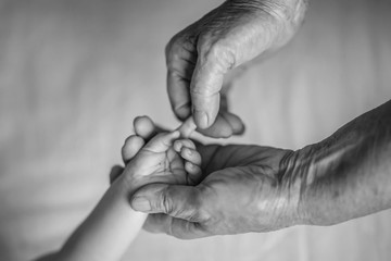 Baby hands in great-grandmother hands. great-grandmother and her great-grandson. Happy Family concept. Beautiful conceptual image of Maternity. selective focus