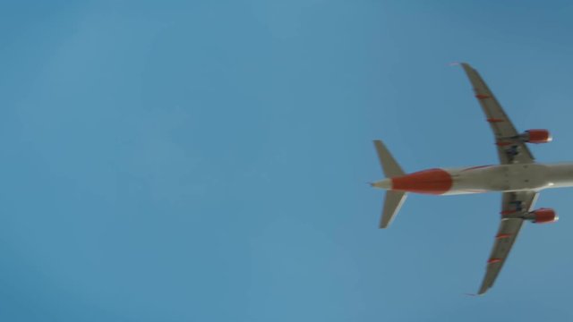 Small cute orange airplane or jet takes off or lands in international private airport on clear sky day. Safe flying and transportation logistics concept. Turbines and wings, engineering miracle