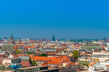 Fototapeta na wymiar Great aerial view of Munich city with the St. Paul's Church in gothic architecture on the left and the high rise office tower Central Tower München in the centre on a nice sunny day with a blue sky.
