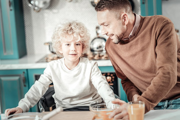 Obraz premium Positive delighted boy sitting at the table