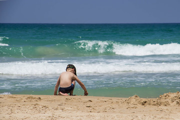 The guy plays on the sand by the blue sea