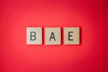 Be my Bae love note with wooden blocks on red background valentines day