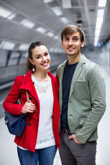 Portrait of couple in jackets at subway station