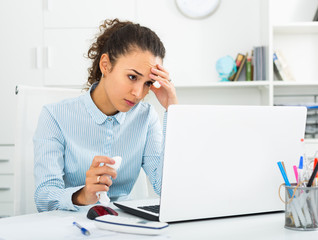 Unhappy business lady working at laptop in office