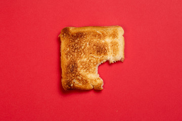 bitten toast on red background