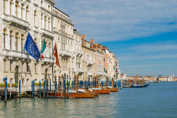 Wooden water taxis and gondolas parked in front of a hotel in Venice Italy