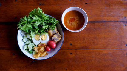 Flat lay Muslim salad with sauce on wood table and have some space for write wording, delicious appetizer with many kinds of vegetable, green leaf lettuce, onion, boiled egg, tofu, high nutrition