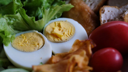 Muslim salad with sauce on wood table and have some space for write wording, delicious appetizer with many kinds of vegetable, green leaf lettuce, onion, boiled egg, tofu, high nutrition