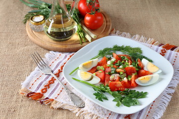 Fresh tomato salad with greens and boiled egg.