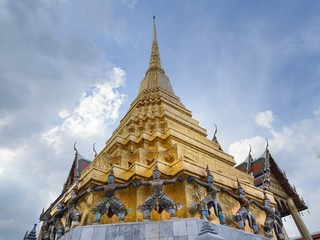 Fototapeta premium Las estatuas de monos y demonios que sostienen la pagoda dorada de Wat Phra Kaew (Templo del Buda Esmeralda), Bangkok, Tailandia
