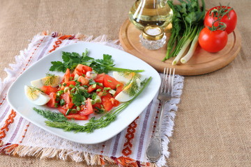 Fresh tomato salad with greens and boiled egg.