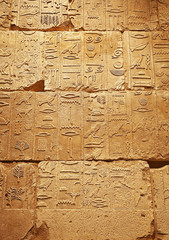 Fototapeta na wymiar Stone wall with ancient Egyptian hieroglyphs
