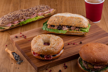 Allsorts of sandwiches and sandwiches on a wooden board with a cup of coffee